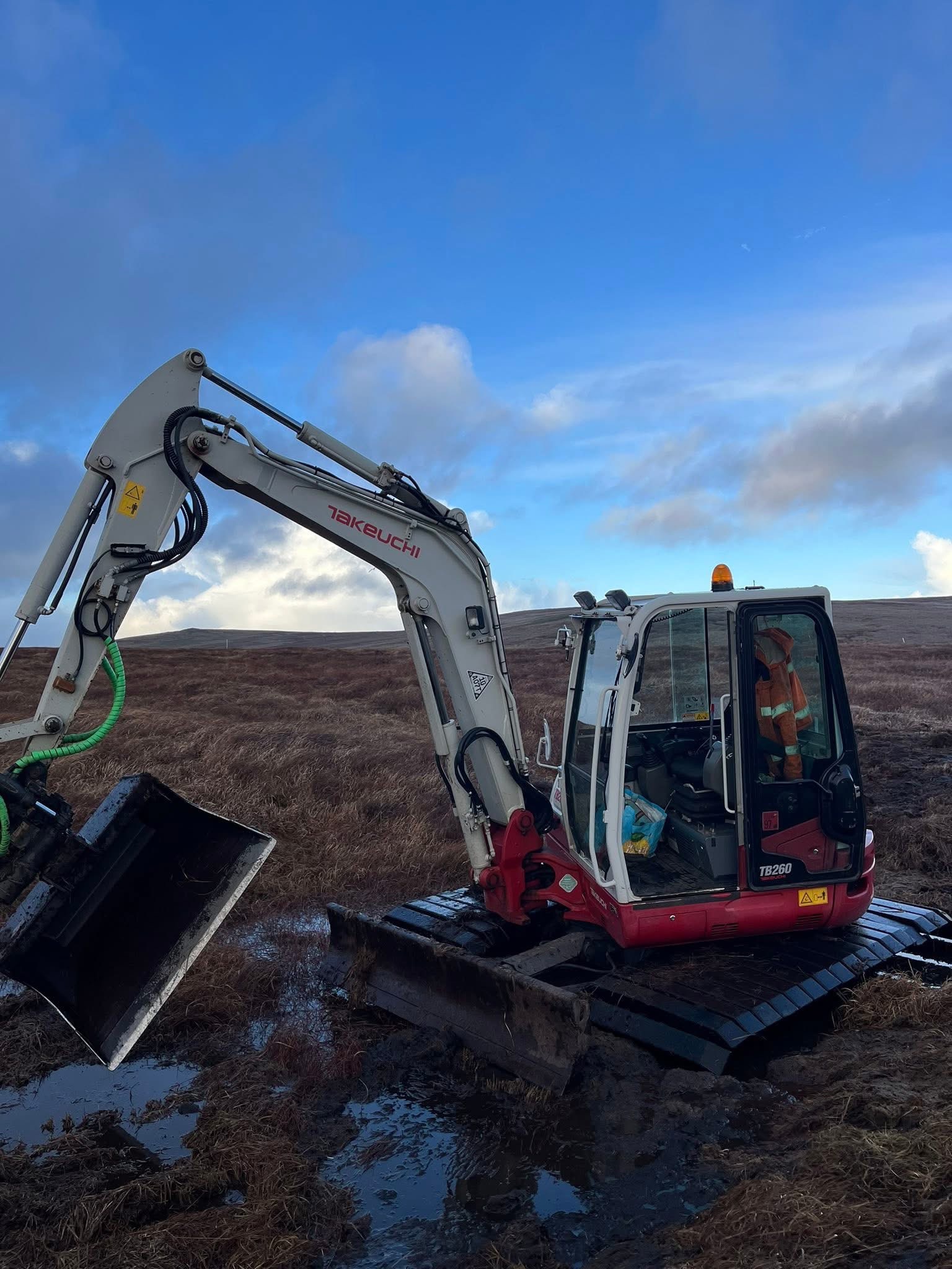 Excavator carrying out peatland restoration on Dartmoor moorland