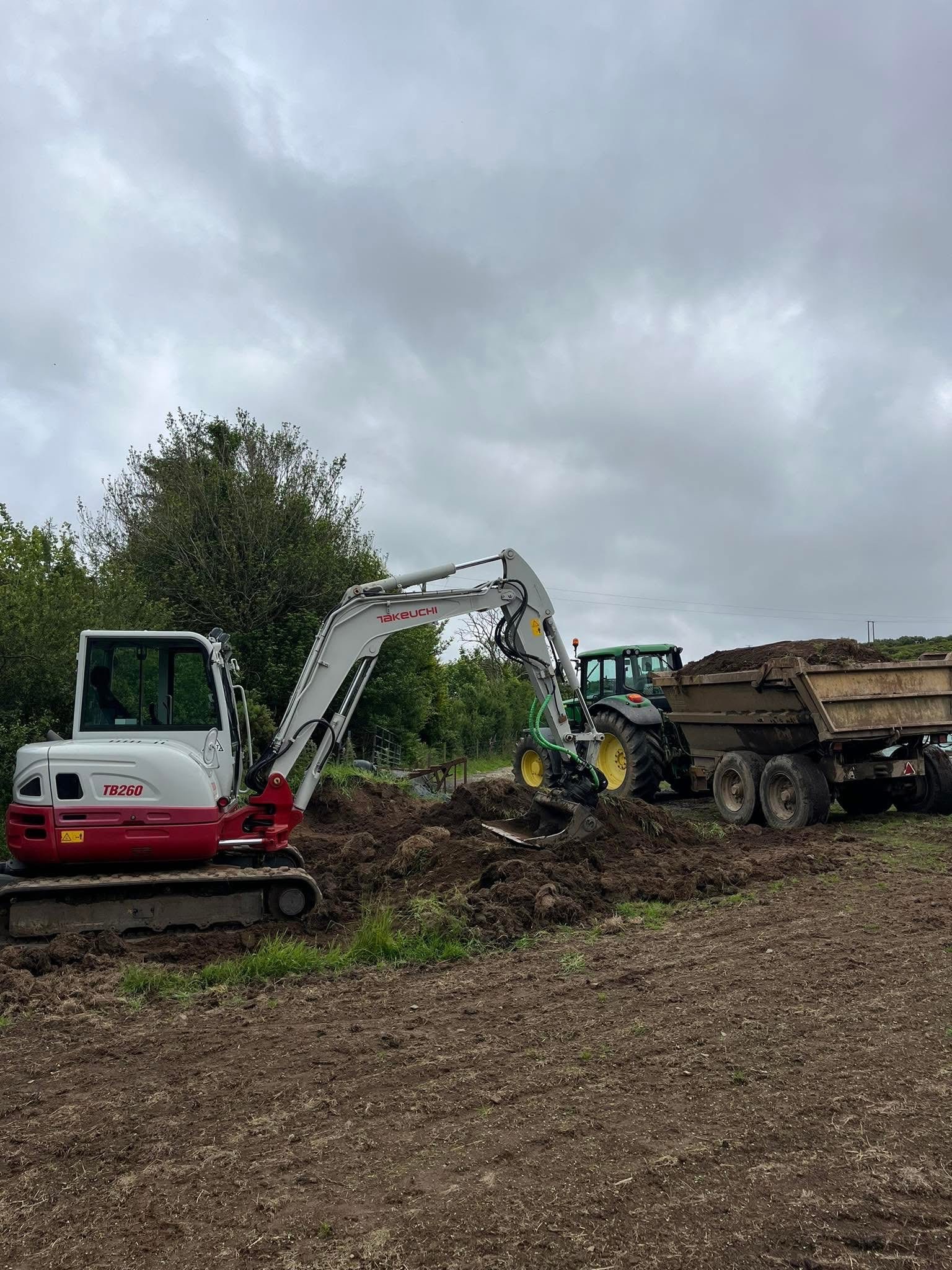Excavator and tractor carrying out rural machine work