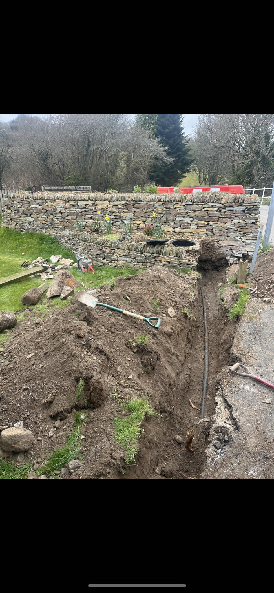Groundworks progress with excavator in a rural field
