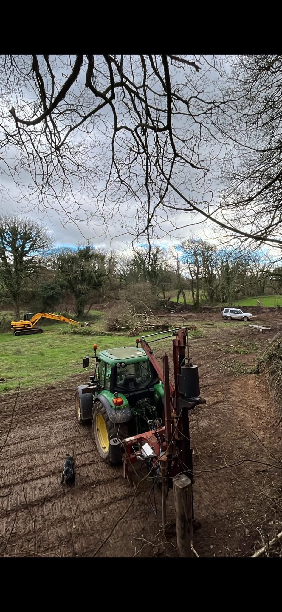 Tractor and post driver on machine work site