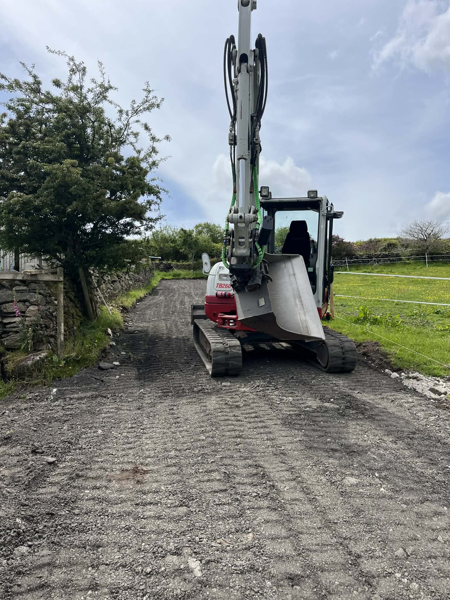 Excavator working during groundwork phase of farm track build